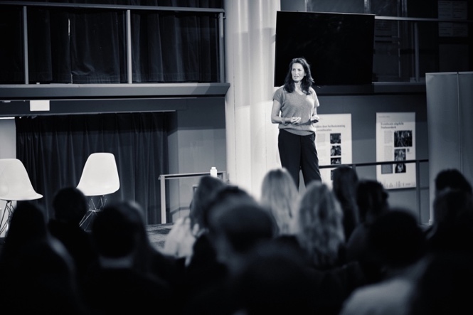 Sasja van Nie op het podium, meer dan 200 aanwezigen in de Amstelkerk Amsterdam